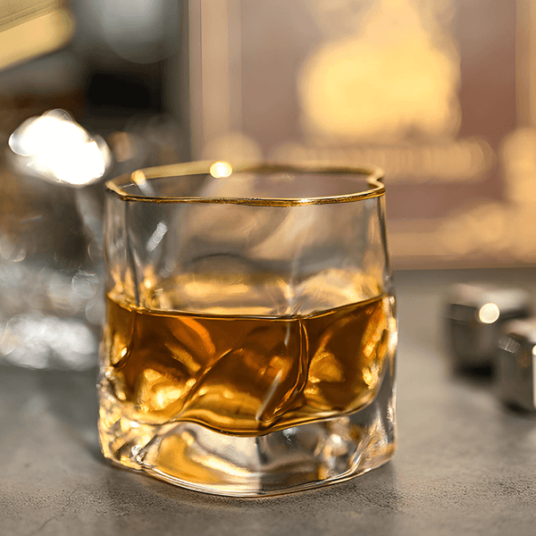 Close-up whisky glass with gold rim holding amber liquid