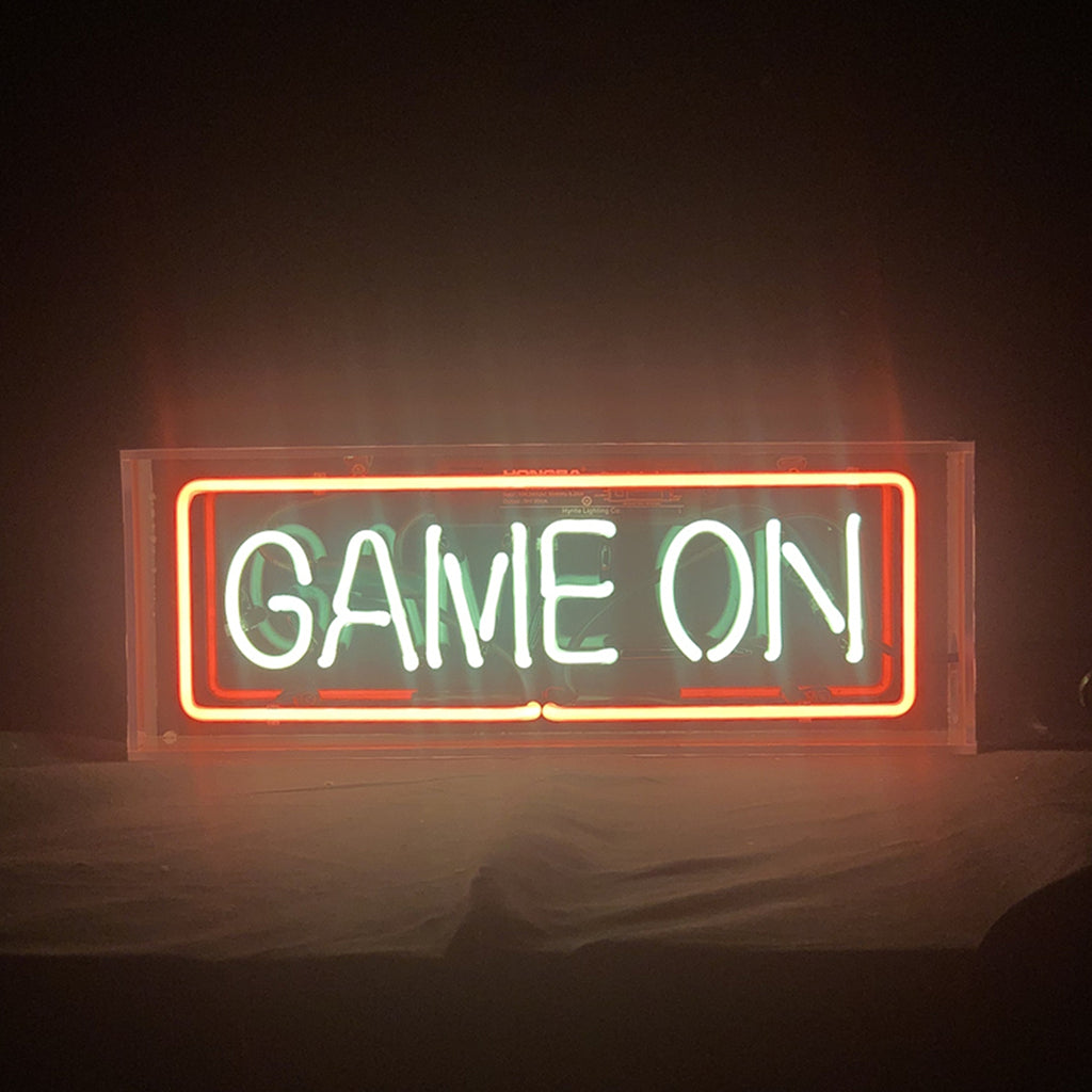 Neon sign reading “GAME ON” with orange-red frame and white text
