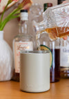 White insulated whiskey lowball tumbler with clear insert held by hands