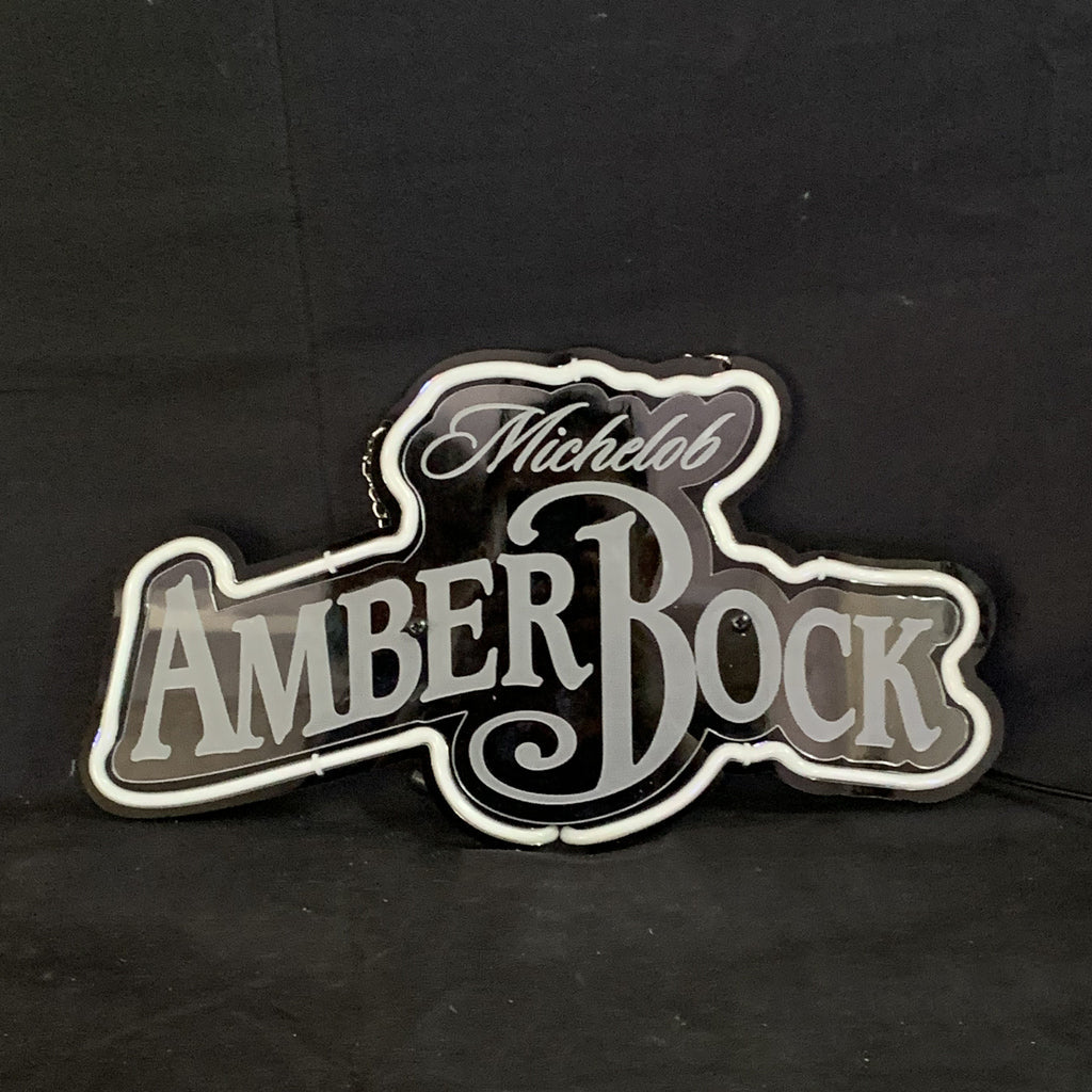Backlit beer neon sign with Michelob Amber Bock logo, white outline on dark surface