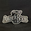Backlit beer neon sign with Michelob Amber Bock logo, white outline on dark surface