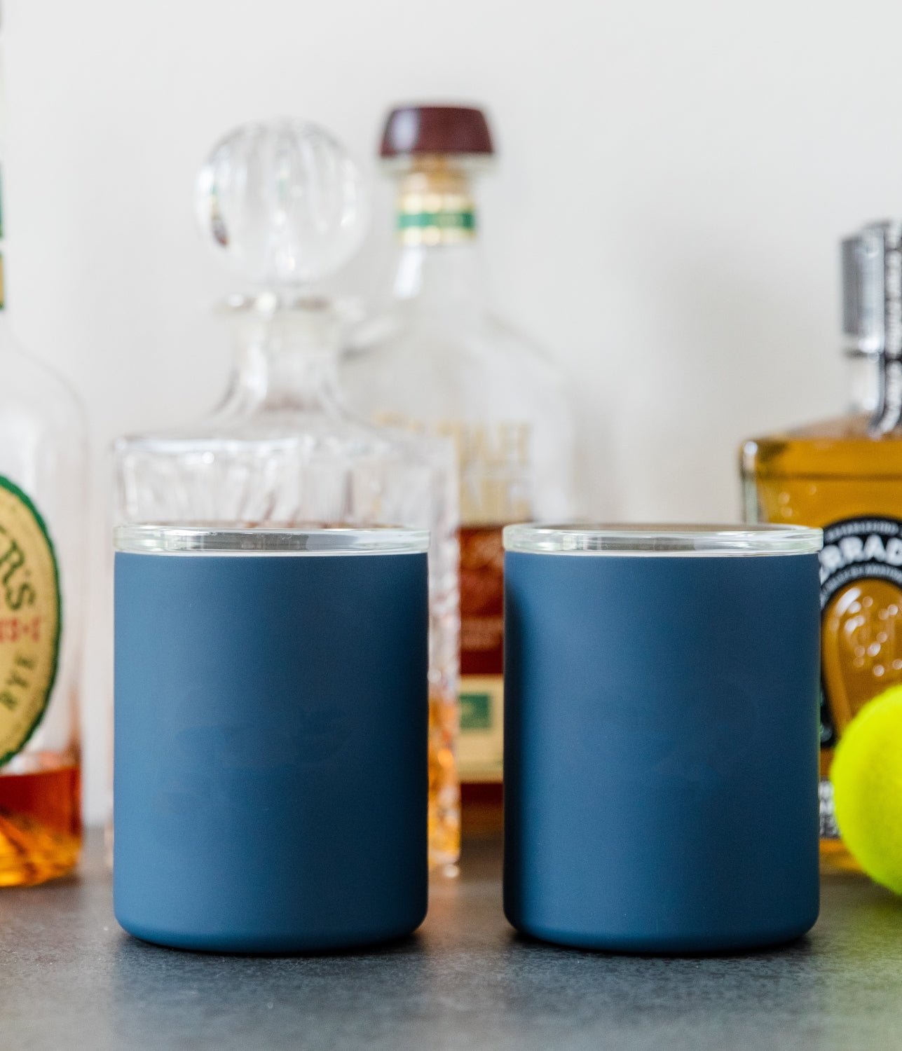 Pair of navy glass-lined lowball whiskey tumblers on a tabletop