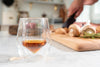 Clear double-walled glass tumbler filled with amber beverage on countertop