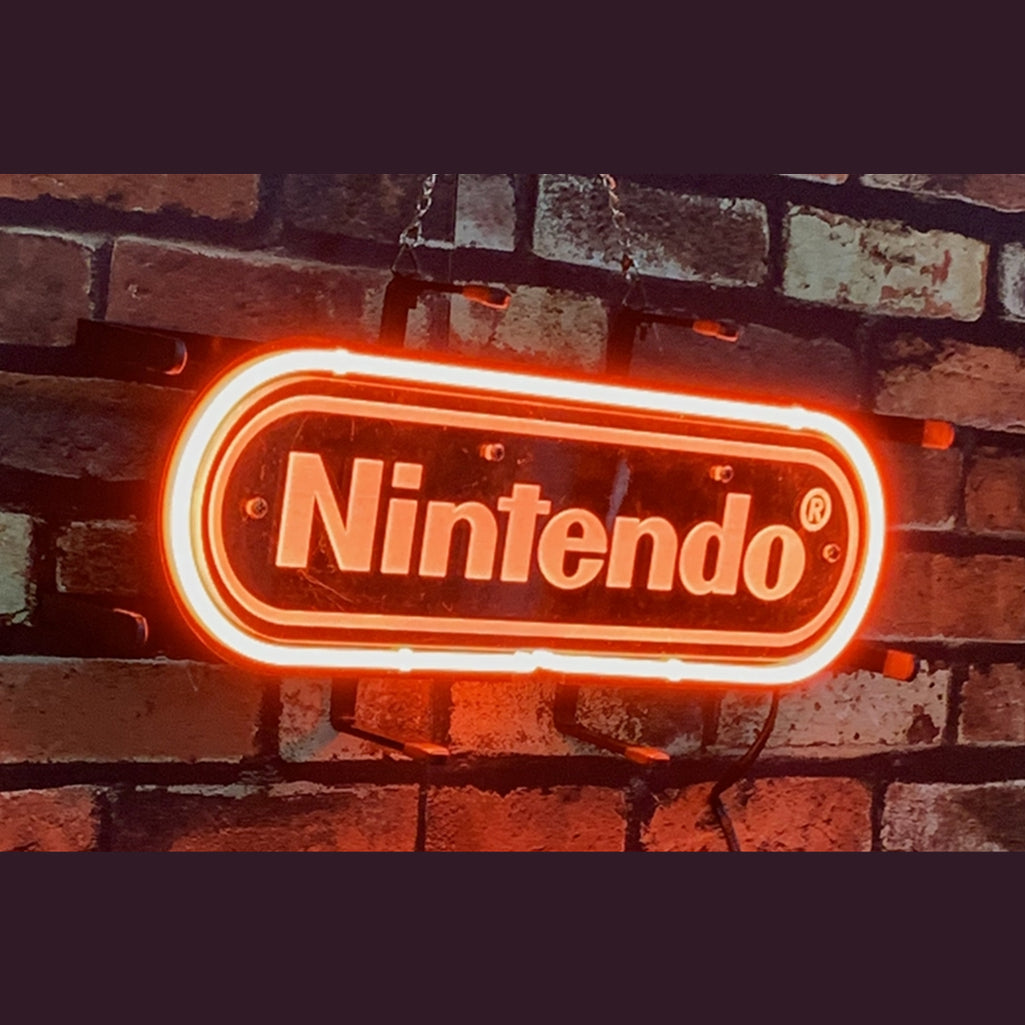 Neon light sign reading Nintendo with glowing white border on brick wall