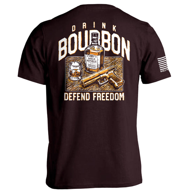 Rust-red T-shirt with back graphic: bourbon bottle, DRINK/BOURBON text, DEFEND FREEDOM