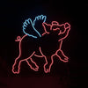 Neon pig with wings outline sign, blue top and pink body glow