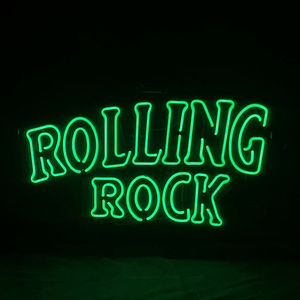 Green neon sign reading “ROLLING ROCK” centered on dark background