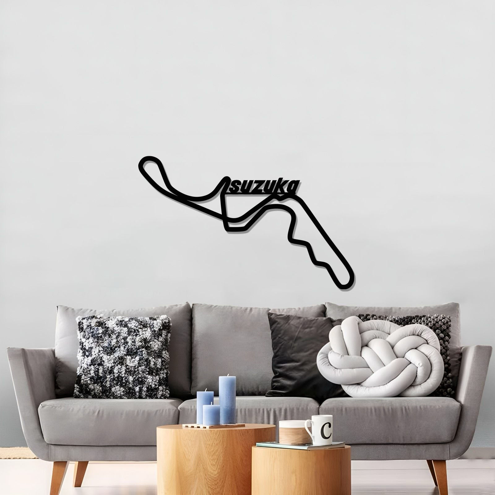 Black Suzuka circuit wall art above a gray sofa