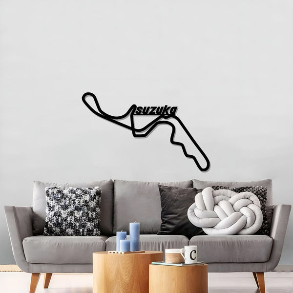 Black Suzuka circuit wall art above a gray sofa