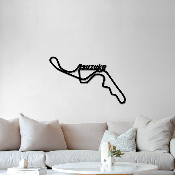 Black Suzuka circuit metal wall art above a white sofa