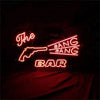Red glowing gun neon sign reading 'The' and 'BANG' with 'BAR' below