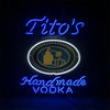 Blue neon sign with centered oval emblem and 'Tito's' and 'Vodka' lettering