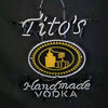 Hanging blue neon sign with chains, oval emblem, and glowing 'Tito's' and 'Vodka'
