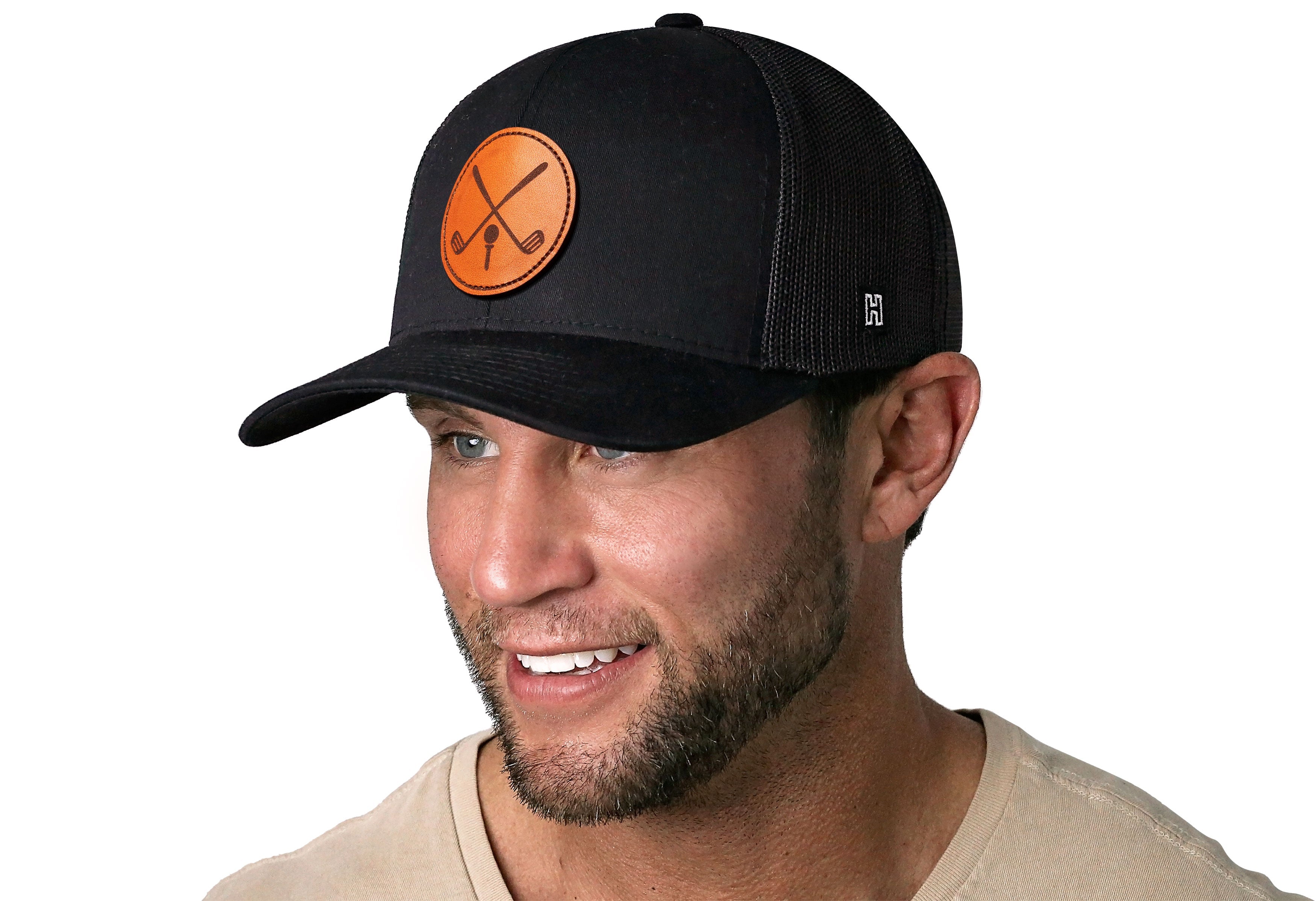 Black trucker cap with orange crossed-clubs leather patch, worn by man