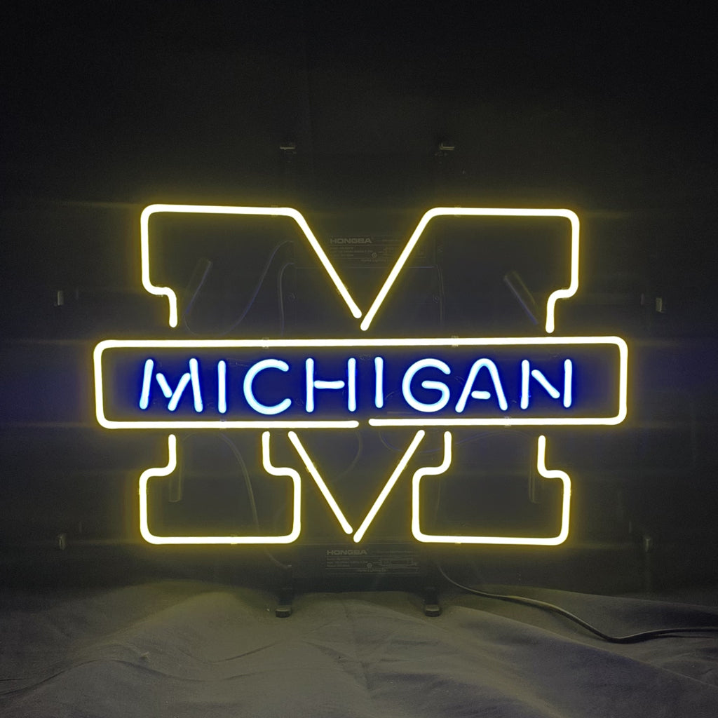 University of Michigan neon logo sign, yellow UM outline, blue MICHIGAN text, with cord