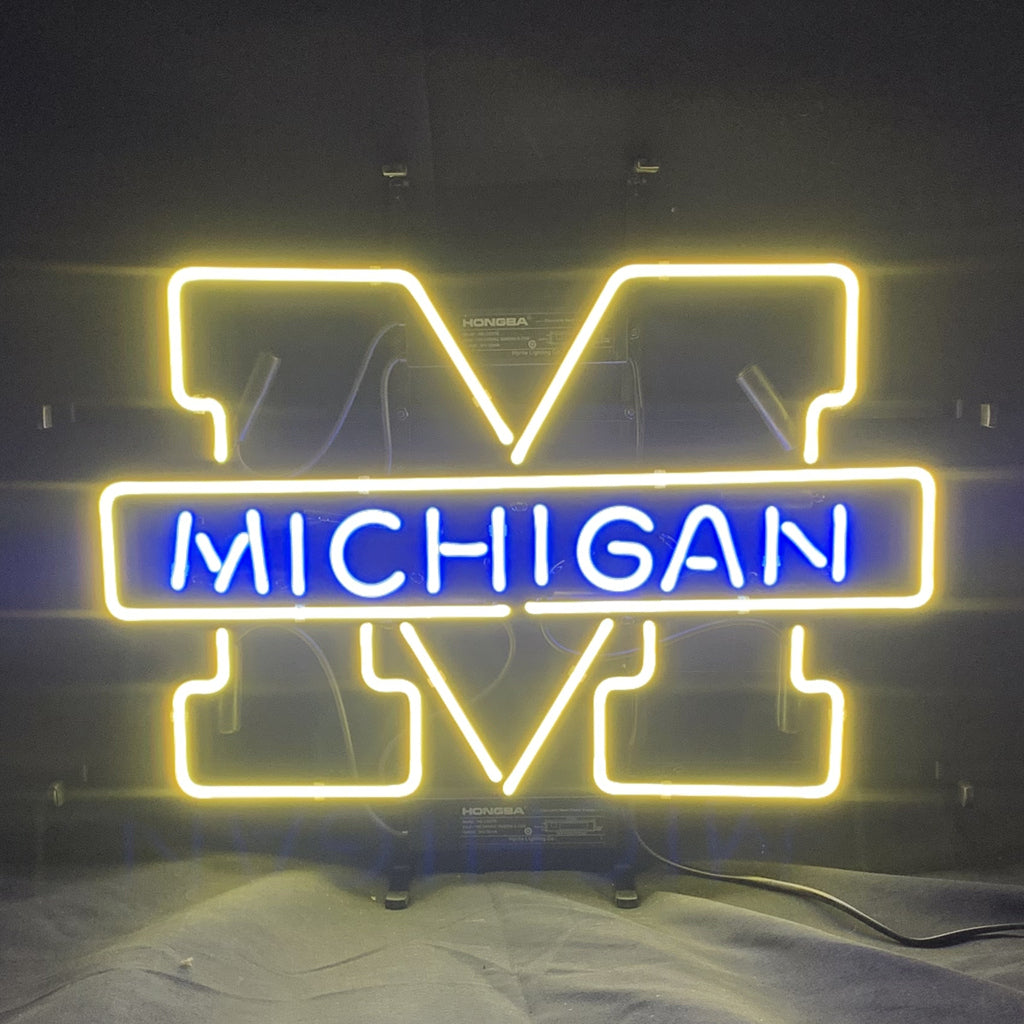 University of Michigan neon logo sign: yellow UM outline with blue MICHIGAN lettering