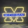 University of Michigan neon logo sign: yellow UM outline with blue MICHIGAN lettering
