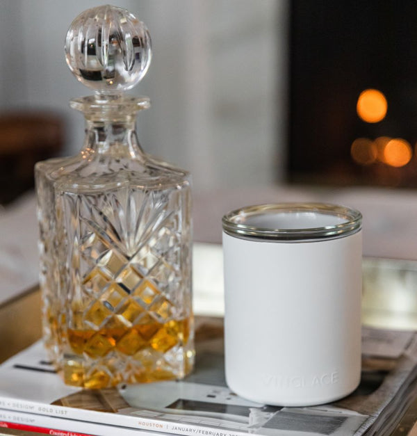 White glass-lined lowball whiskey tumbler with a clear glass decanter beside it