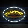 Oval neon sign with bright yellow 'DEADWOOD' and 'Cigar Bar' center text