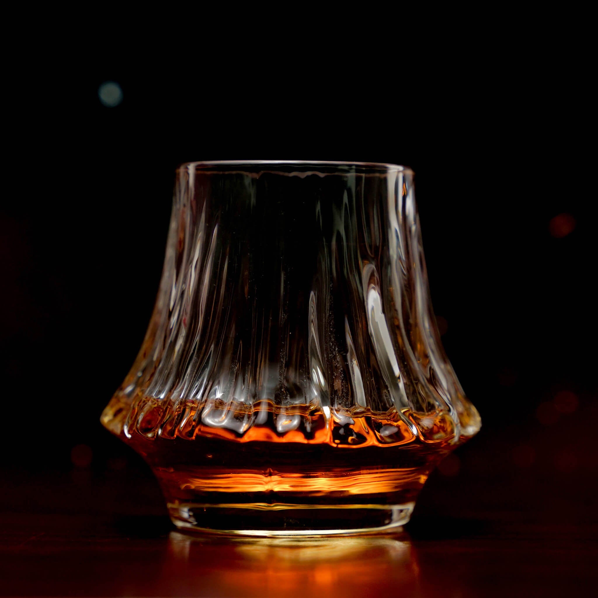 Fluted crystal whisky glass holding amber whisky