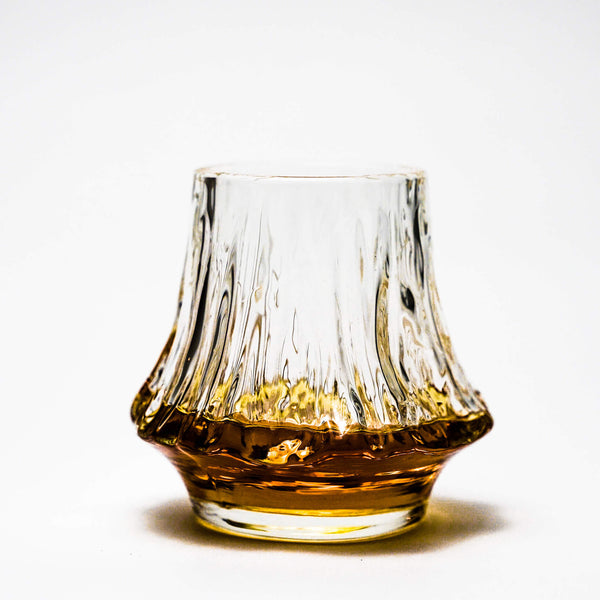 Japanese crystal whisky glass with amber liquid and fluted texture around the sides