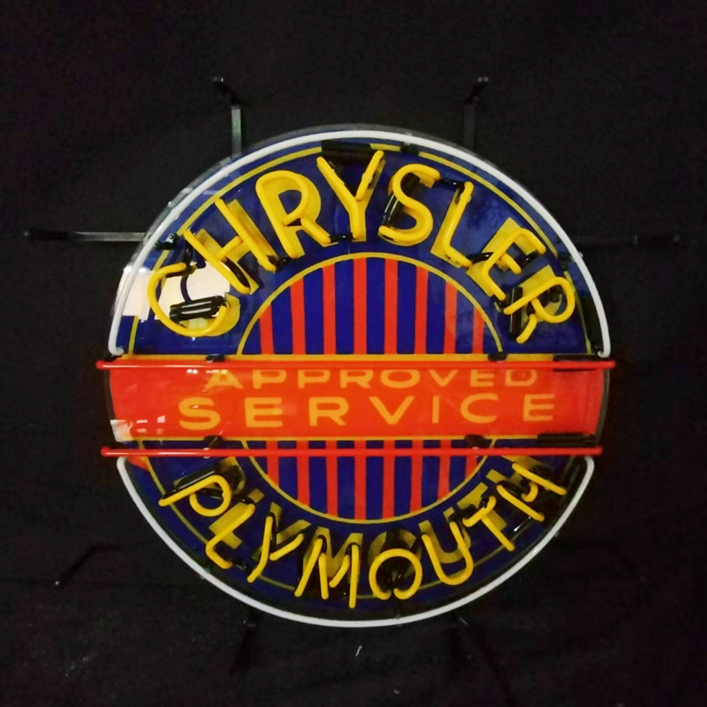 Neon logo sign reading CHRYSLER and PLYMOUTH with 'APPROVED SERVICE' banner