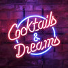 Neon cocktail and dreams wall sign with blue and pink glowing script