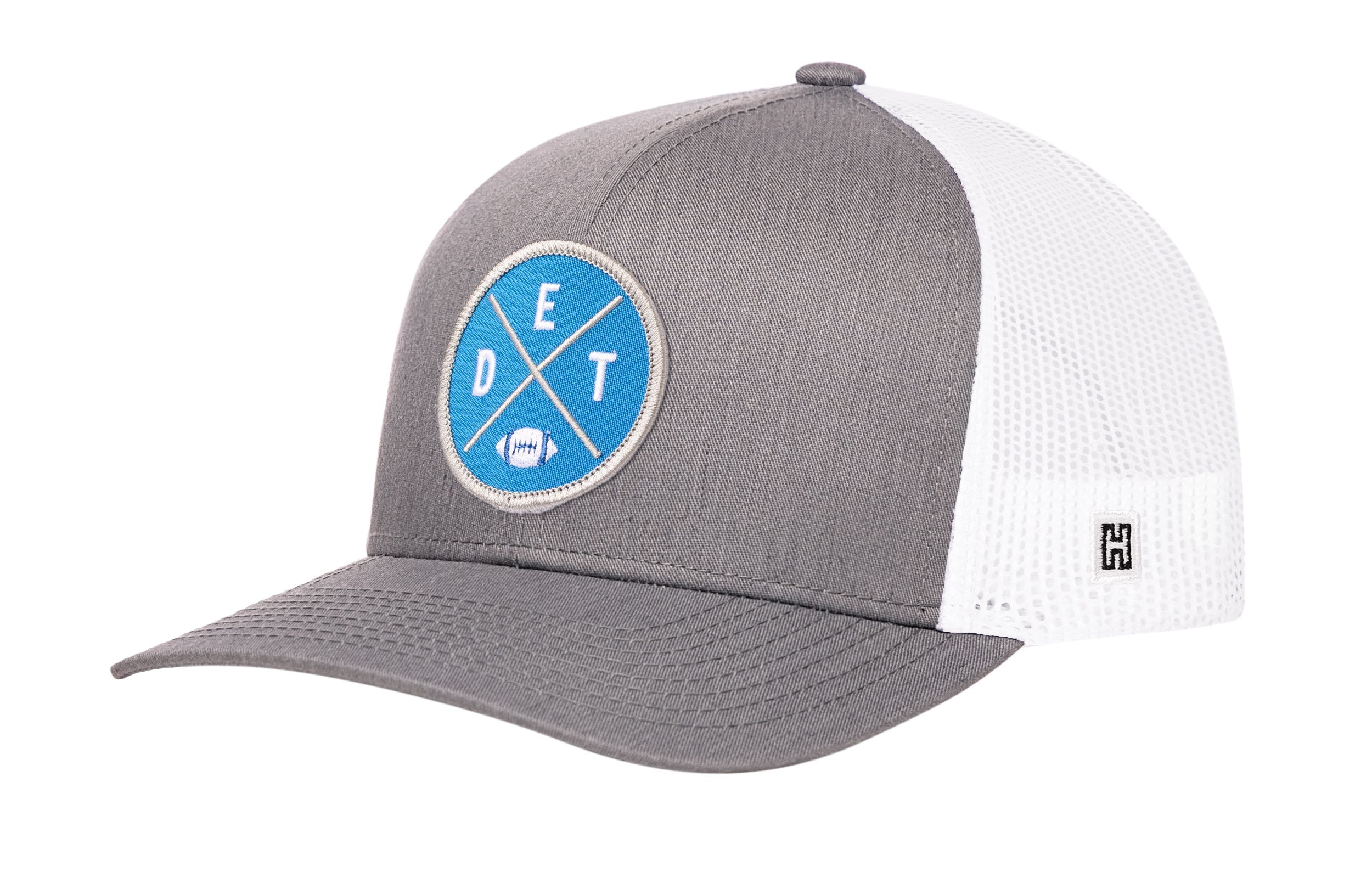 Gray and white trucker hat with blue DET X logo patch, curved brim, and mesh back.