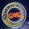 Neon circular sign with 'General Motors' ring text and 'Trucks' beneath GM CMC logo.