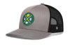 Gray trucker hat with green GB logo patch and black mesh side panels.