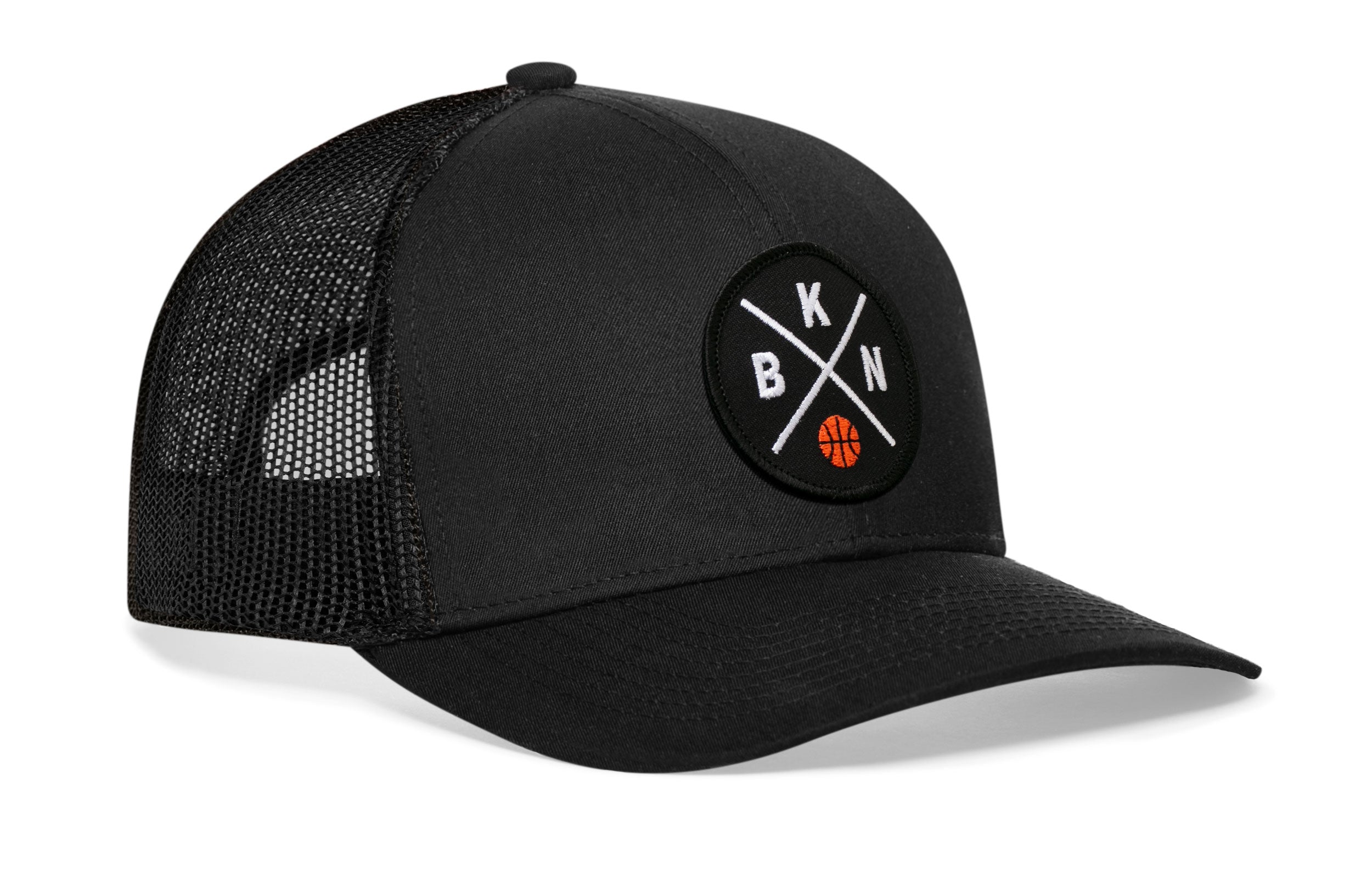 Black trucker cap with circular front patch logo, black mesh side panels, curved brim