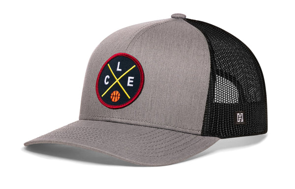 Gray front trucker cap with black mesh back and circular logo patch