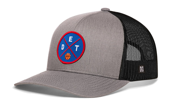 Gray trucker baseball cap with circular basketball logo patch and black mesh side panels