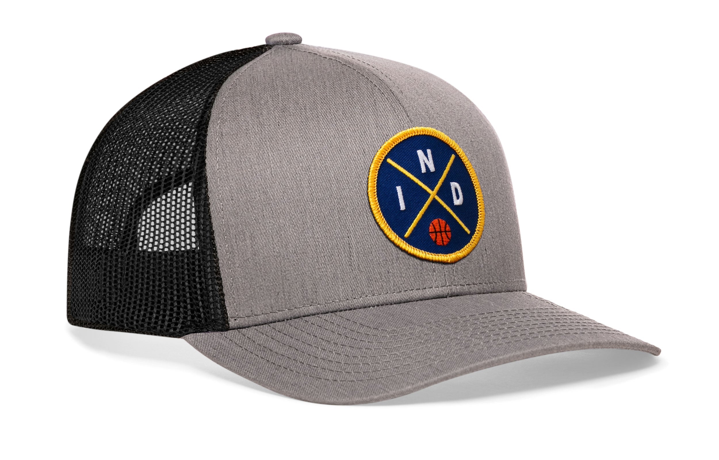 Gray-and-black trucker snapback hat with front-right circular logo patch and mesh back panel.