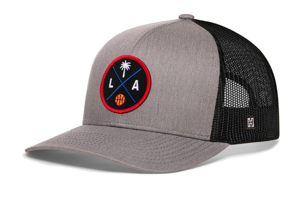 Gray trucker cap with black mesh back and round LA logo patch, snapback closure