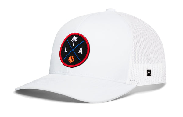 White trucker baseball cap with mesh back, round LA logo patch, snapback closure