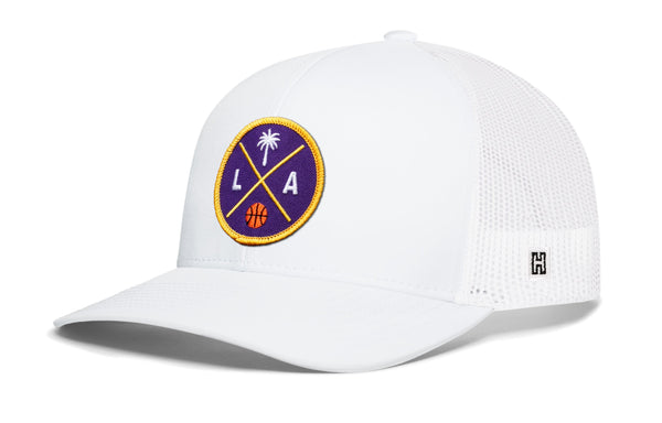 White basketball trucker hat with circular LA graphic patch and side H logo