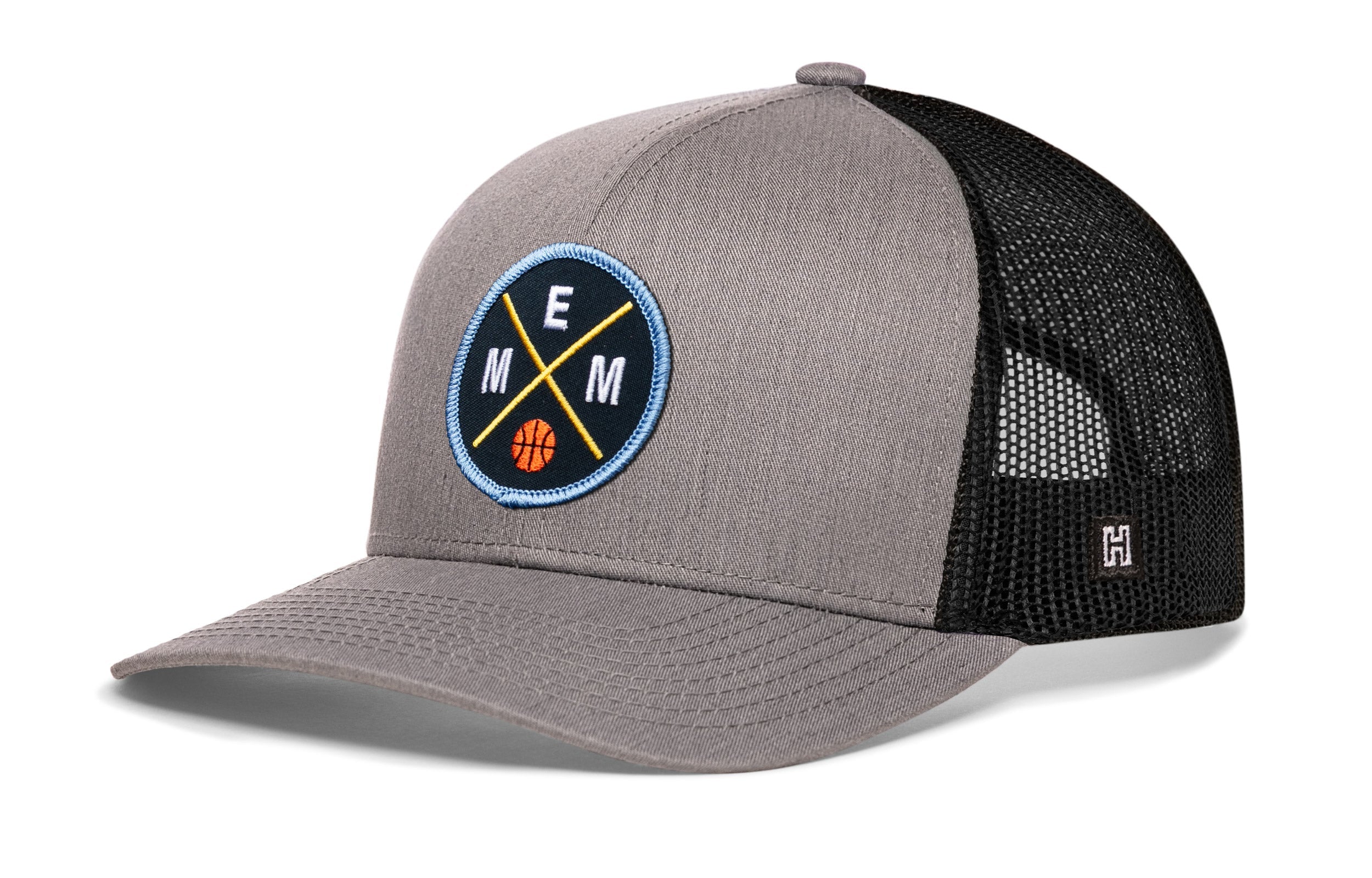 Gray and black basketball trucker hat with circular EMM logo patch and mesh back