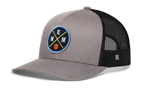 Gray and black basketball trucker hat with circular EMM logo patch and mesh back