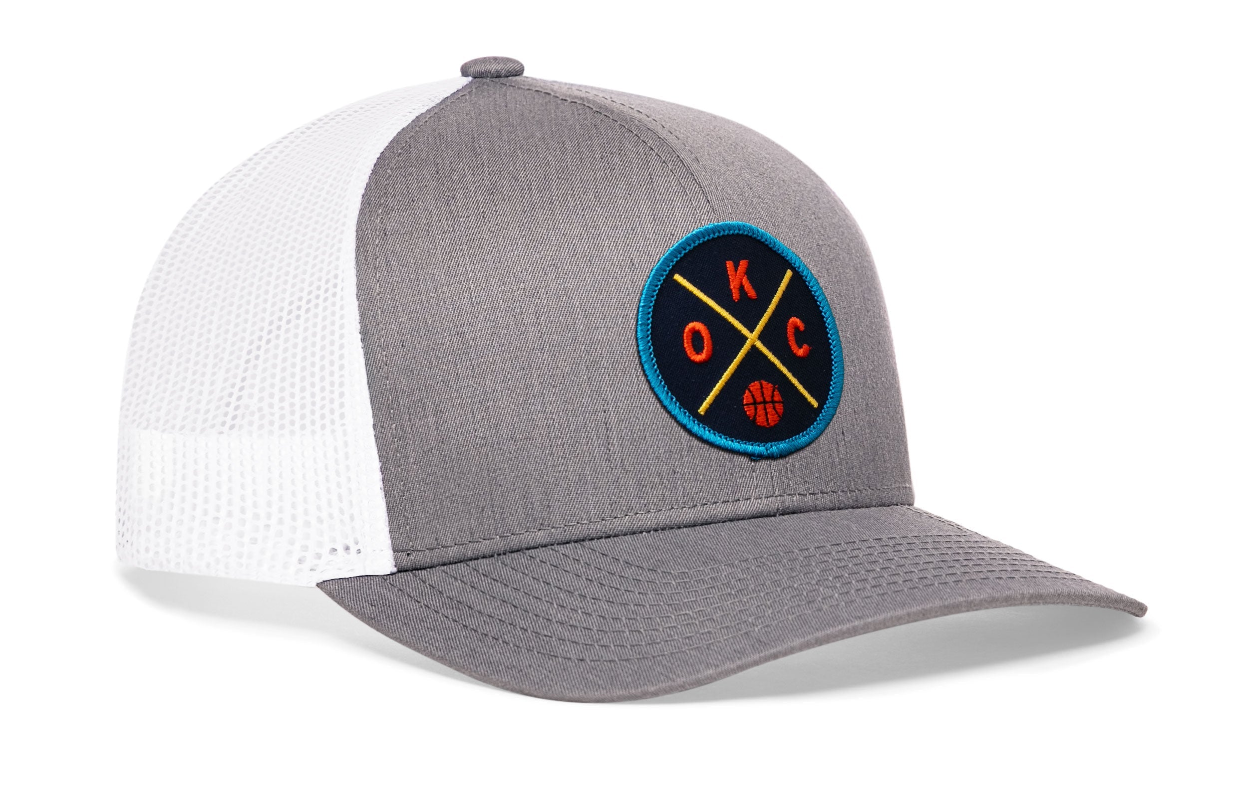 Gray and white trucker hat with mesh sides and circular team logo patch on the front.
