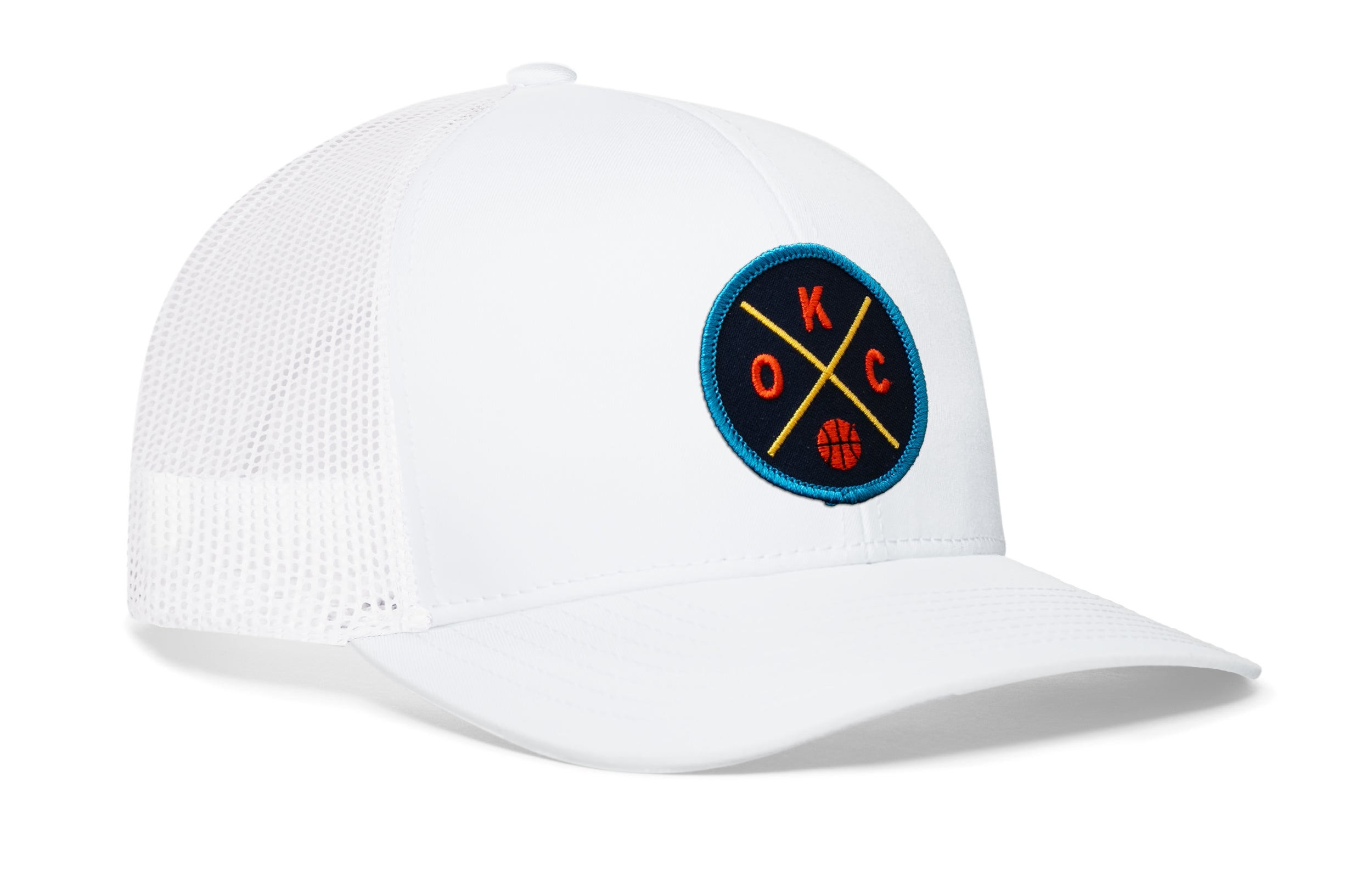 White trucker hat with mesh sides and circular team logo patch on the front panel.