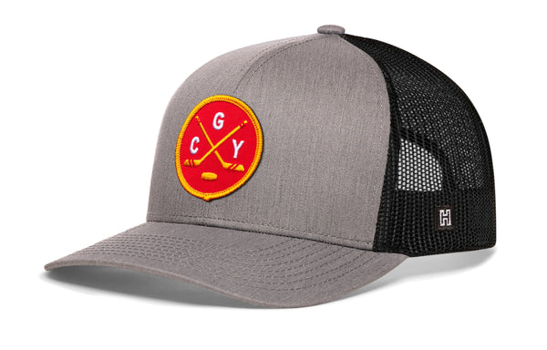 Gray-and-black trucker snapback hat with circular “CGY” patch and mesh sides.