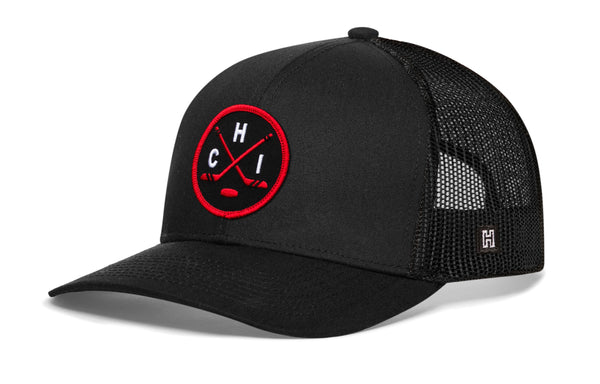 Black trucker cap with red-and-black circular emblem and front logo, mesh side panels.