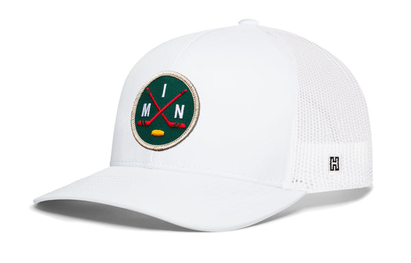White trucker hat with round hockey logo patch, mesh back, and H side emblem, snapback.