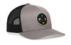 Gray trucker hat with black mesh back and round hockey logo patch on front, curved brim.