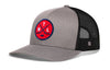 Gray trucker hat with black mesh sides, curved brim, and red circular crest patch on front