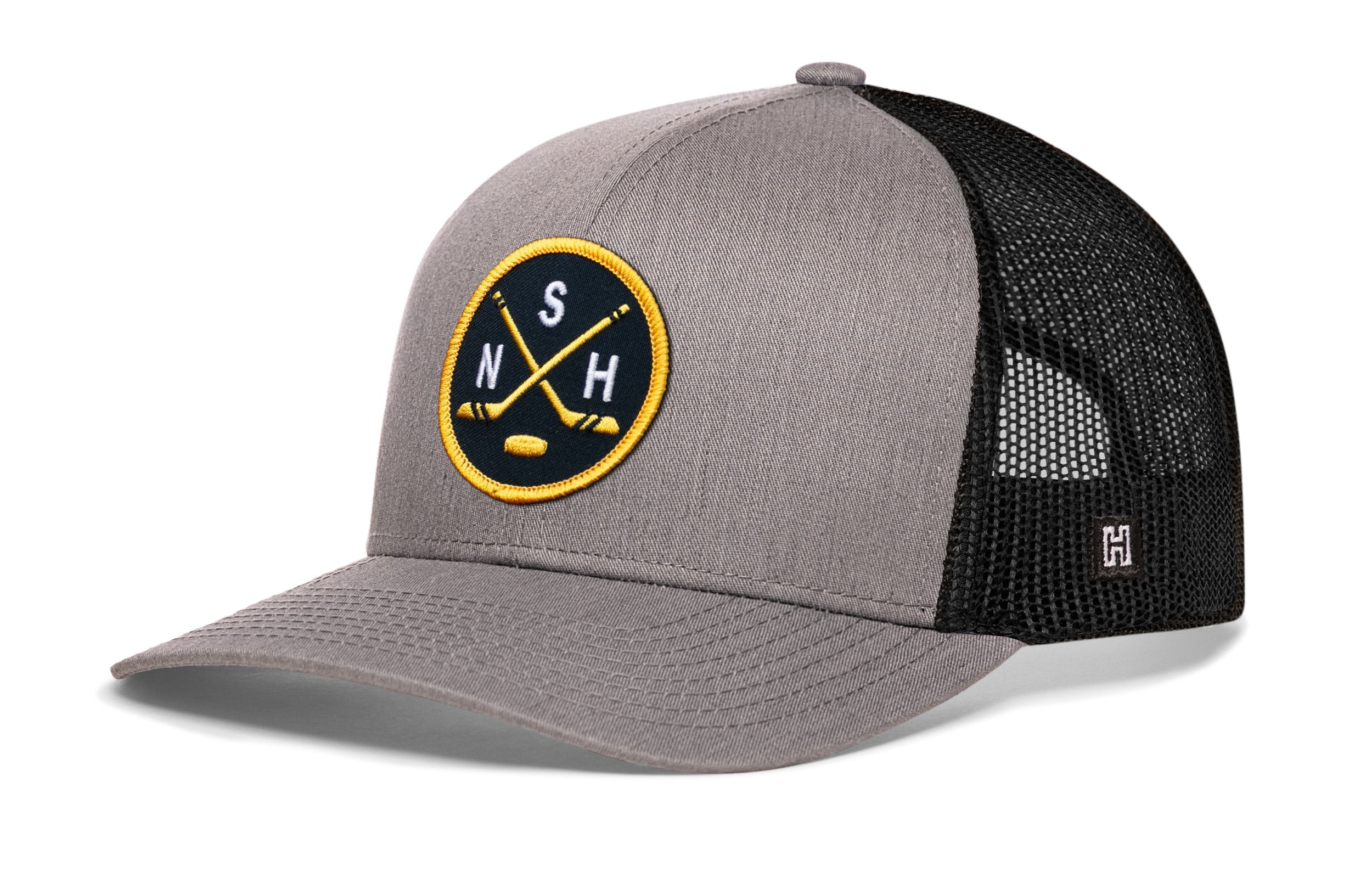 Gray and black trucker cap with circular logo patch and mesh side panels.