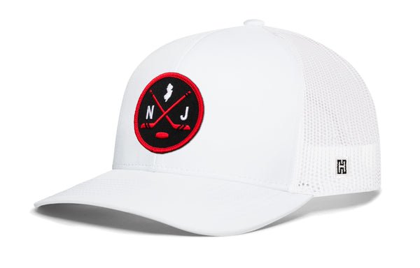 White hockey trucker cap with red logo patch, mesh side panels, snapback closure