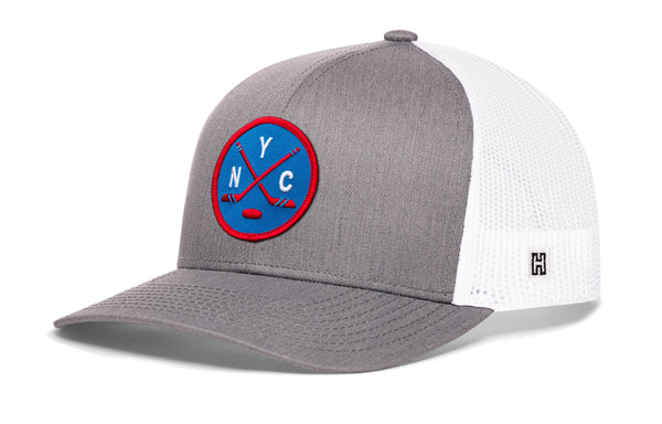 Gray hockey trucker hat with circular front patch, white mesh back, snapback closure.