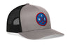 Gray hockey trucker hat with circular front patch, black mesh side panels, snapback.